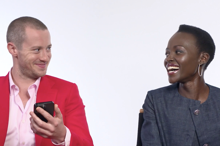 Lupita Nyong'o and Joseph Quinn are seated laughing