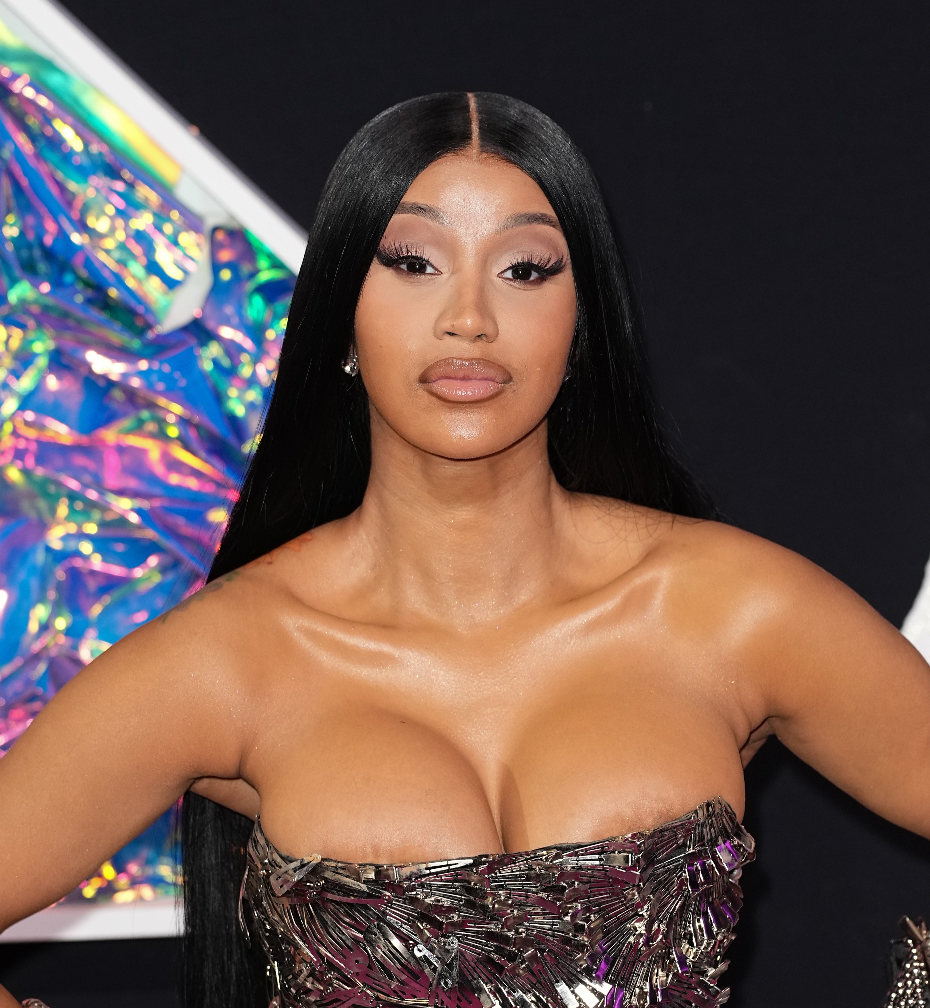 Cardi B poses on the red carpet wearing a strapless, metallic-patterned dress