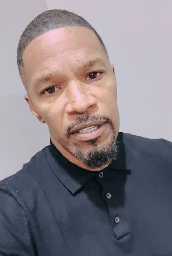 Jamie Foxx in a close-up shot, wearing a dark polo shirt and looking directly at the camera